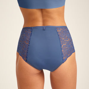 Modell trägt ooia Highwaist Lace Extra Strong in Smoky Blue – elegante Periodenunterwäsche mit hohem Spitzenbund und Spitzeneinsätzen. Rückansicht.