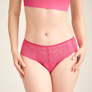 Modell trägt ooia Hipster Allover Lace in Hot Pink – Periodenslip mit durchgehender floraler Spitze
