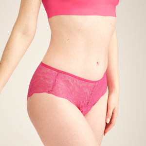 Modell trägt ooia Hipster Allover Lace in Hot Pink – Periodenslip mit durchgehender floraler Spitze
