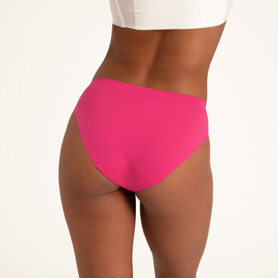 Modell trägt ooia Slip Seamless in hot pink - nahtloser Periodenslip. Rückansicht