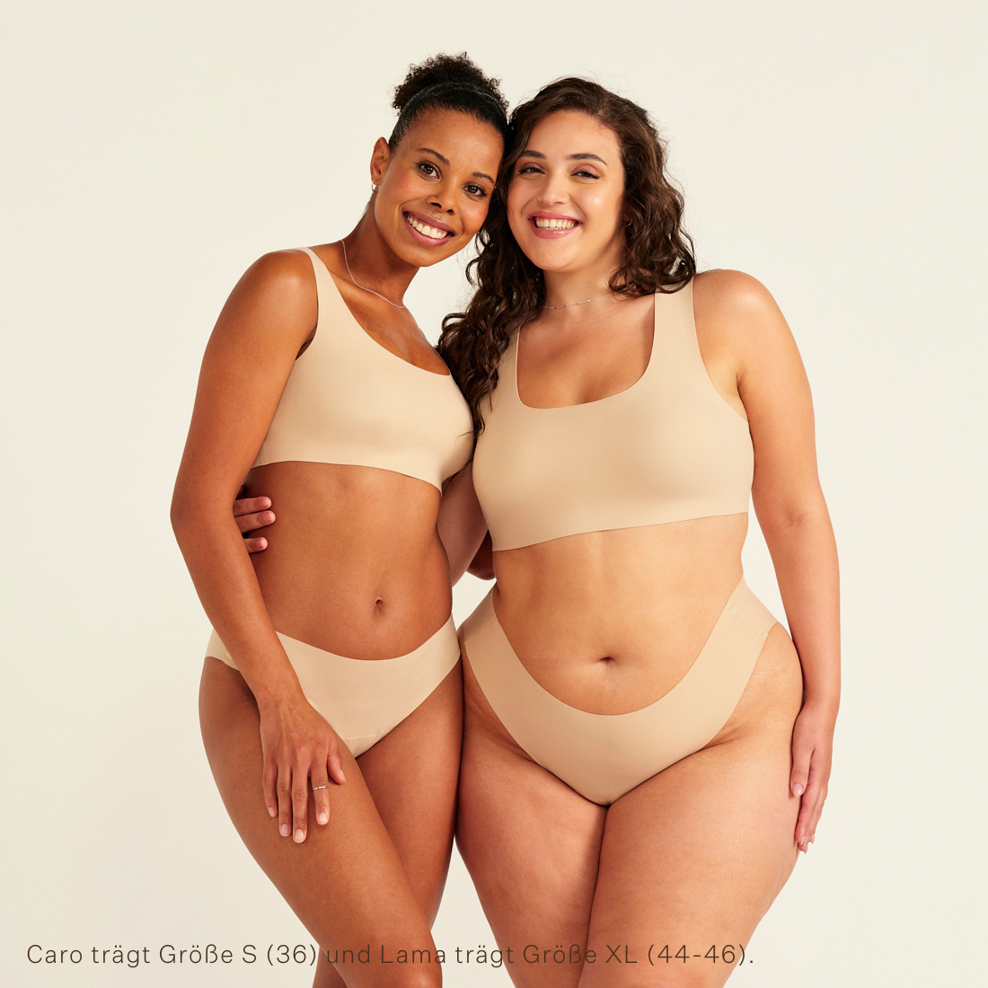 Zwei Models unterschiedlicher Konfektion tragen ooia All-You-Need Bra Top in Beige – bügelloses, nahtloses Bustier mit breiten Trägern, dazu passed Periodenslip Seamless in Beige.