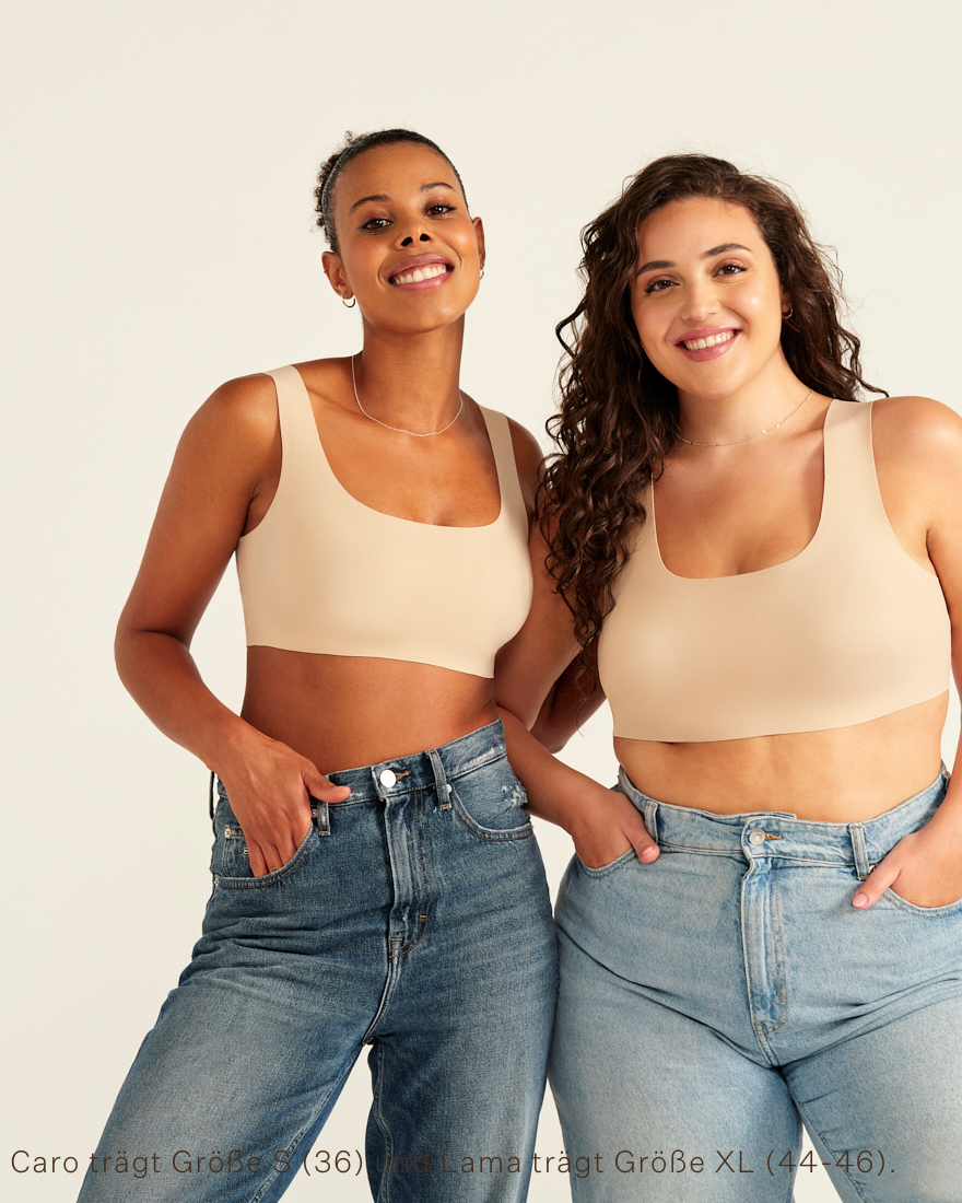 Zwei Models unterschiedlicher Konfektion tragen ooia All-You-Need Bra Top in XL in Beige – bügelloses, nahtloses Bustier mit breiten Trägern, als Top zu Jeans.
