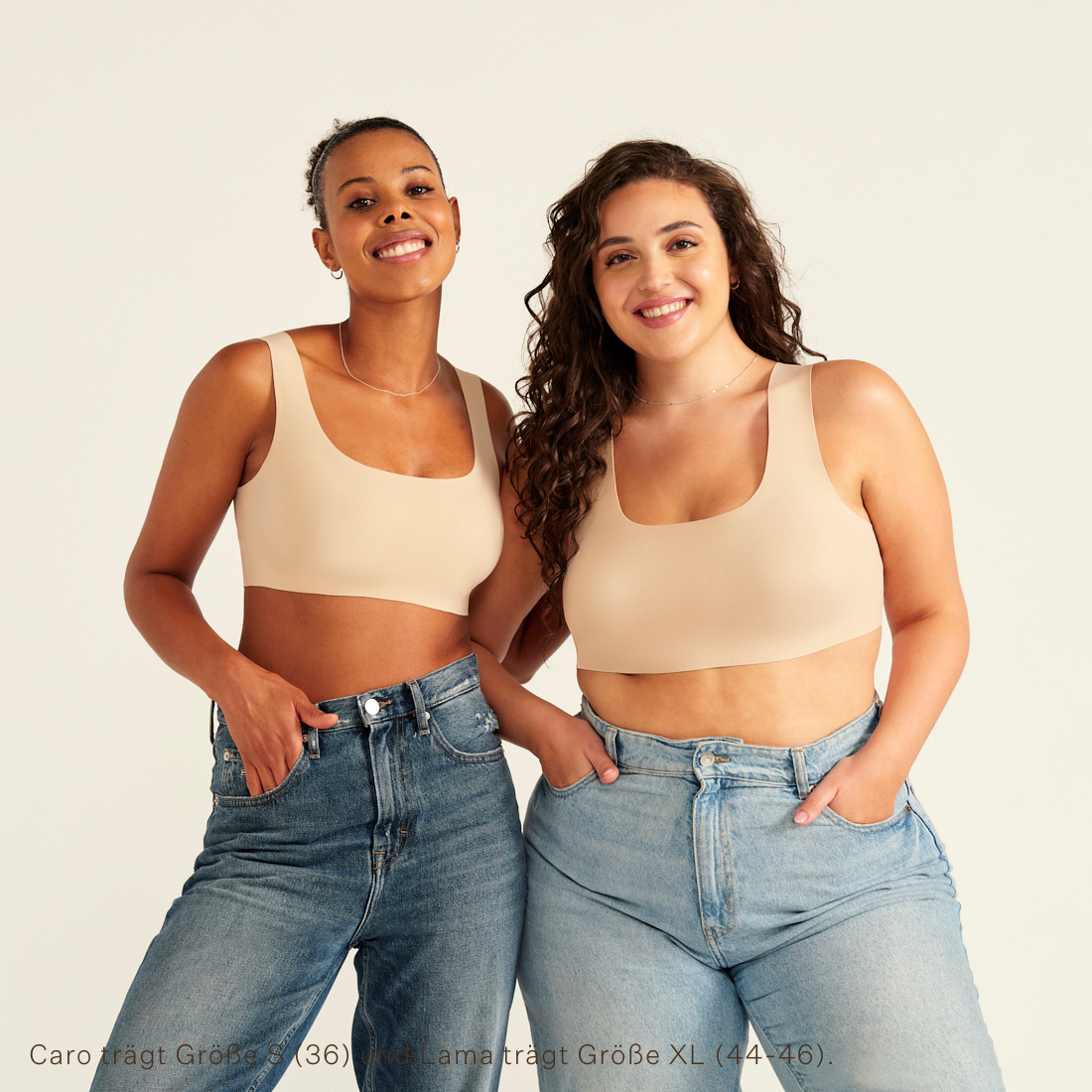 Zwei Models unterschiedlicher Konfektion tragen ooia All-You-Need Bra Top in XL in Beige – bügelloses, nahtloses Bustier mit breiten Trägern, als Top zu Jeans.
