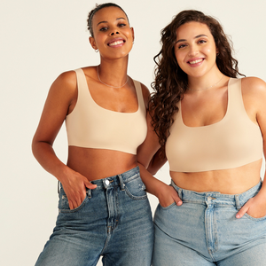 Zwei Models unterschiedlicher Konfektion tragen ooia All-You-Need Bra Top in XL in Beige – bügelloses, nahtloses Bustier mit breiten Trägern, als Top zu Jeans.