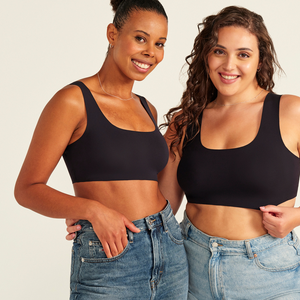 Zwei Models unterschiedlicher Konfektion tragen ooia All-You-Need Bra Top in Schwarz – bügelloses, nahtloses Bustier mit breiten Trägern, dazu Jeans.