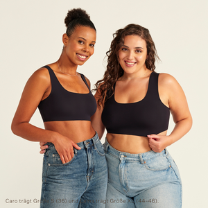 Zwei Models unterschiedlicher Konfektion tragen ooia All-You-Need Bra Top in Schwarz – bügelloses, nahtloses Bustier mit breiten Trägern, dazu Jeans.