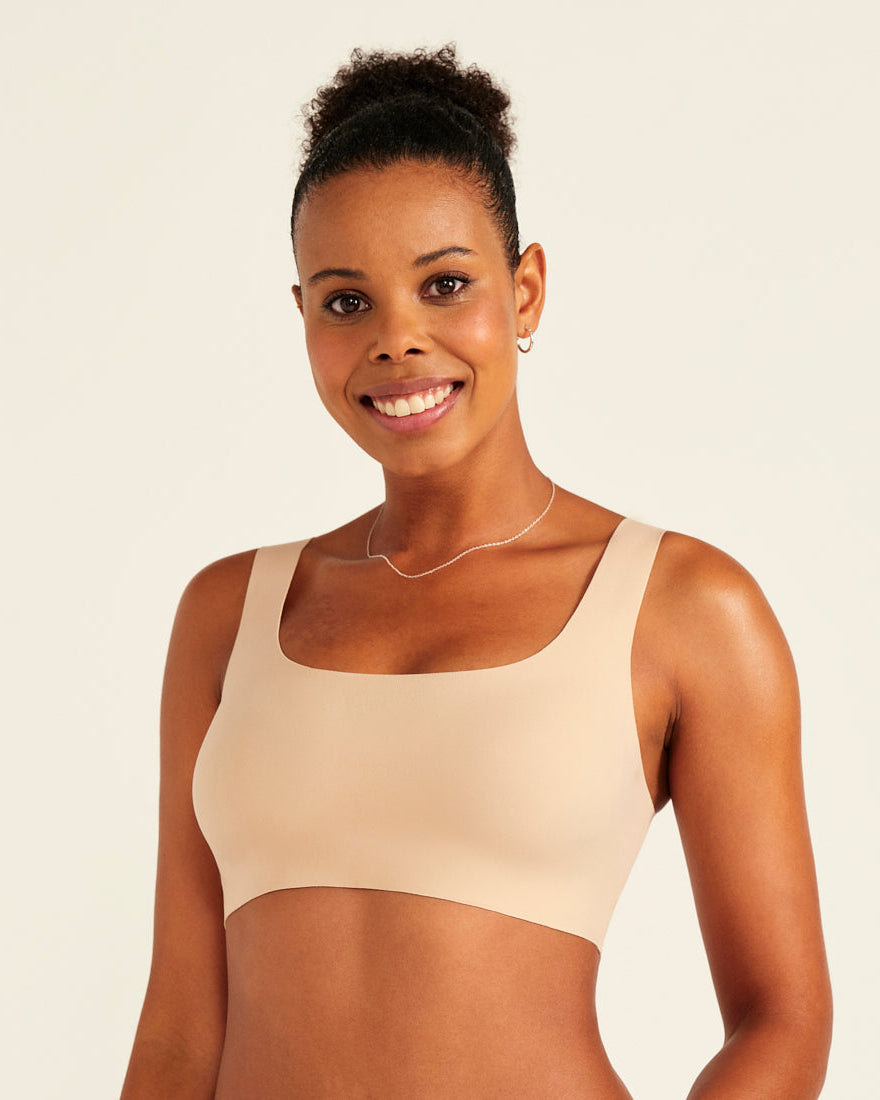 Modell trägt ooia All-You-Need Bra Top in Beige – bügelloses, nahtloses Bustier mit breiten Trägern