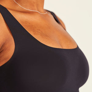 Modell trägt ooia All-You-Need Bra Top in Schwarz – bügelloses, nahtloses Bustier mit breiten Trägern.