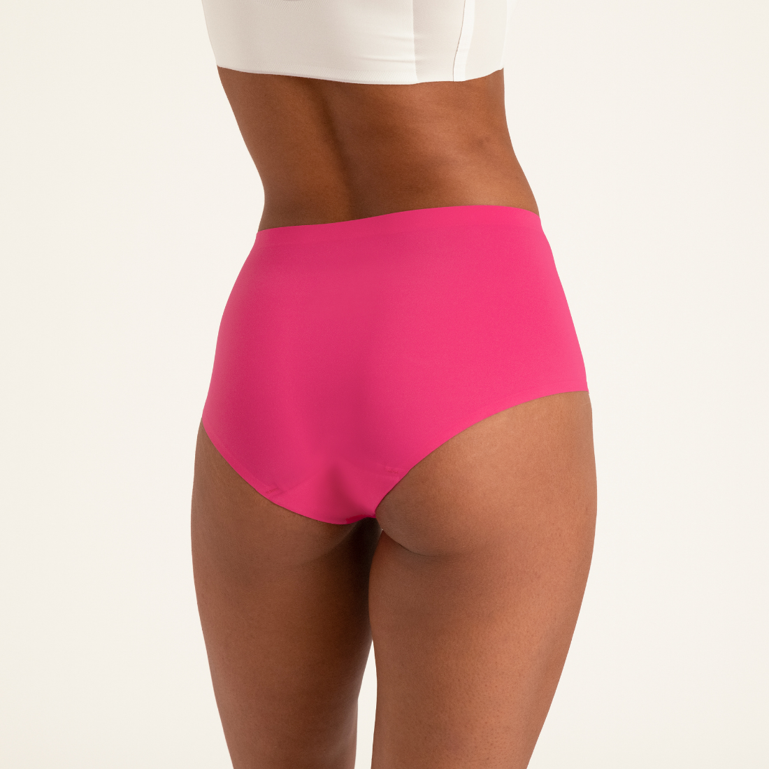 Modell trägt ooia Highwaist Seamless Periodenslip in Hot Pink – nahtlose Unterwäsche mit hohem Bund. Rückansicht.