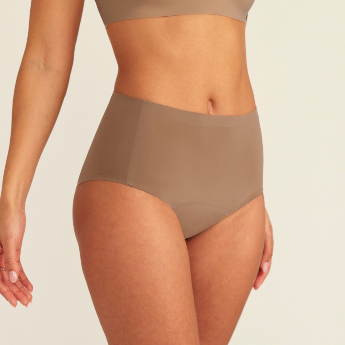 Modell trägt ooia Periodenunterwäsche Highwaist Seamless in Taupe mit hohem Bund und nahtlosem Design