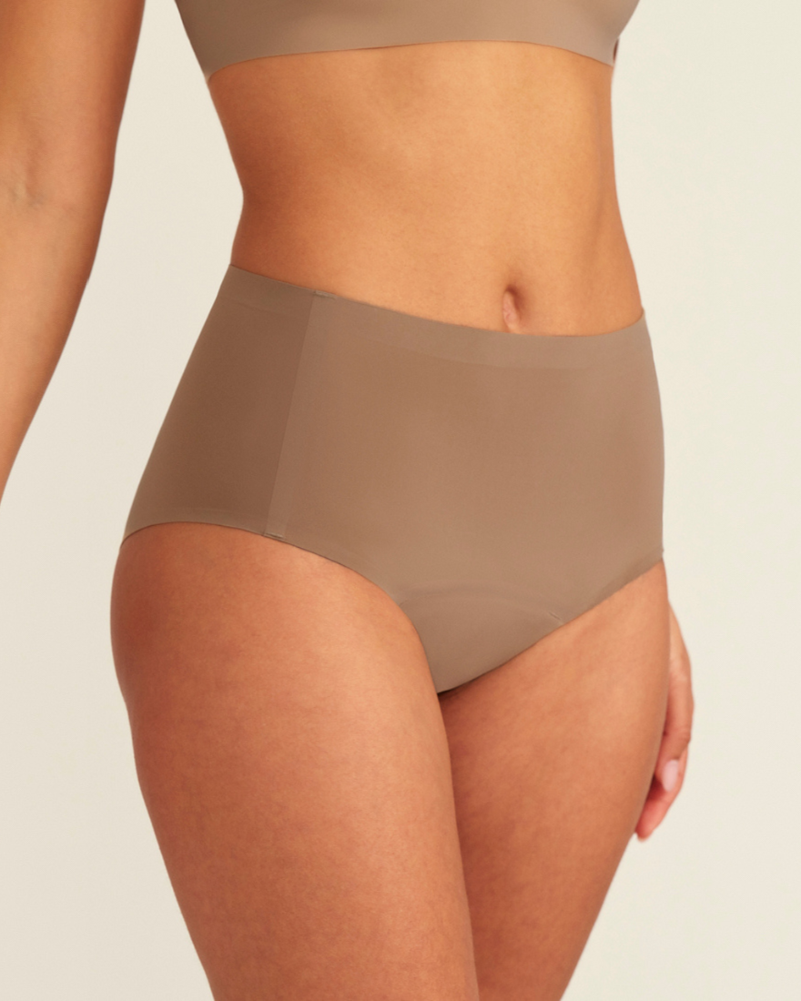 Modell trägt ooia Periodenunterwäsche Highwaist Seamless in Taupe mit hohem Bund und nahtlosem Design