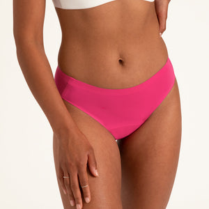 Model trägt den nahtlosen Periodenslip namens Slip Seamless von ooia in hot pink im bequemen & modernen Design.