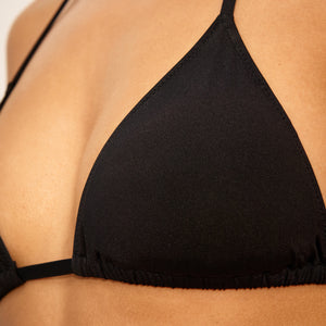Das Modell trägt ooia Bademode Triangle Top in schwarz zum Binden im Hals und Rücken.
Detail