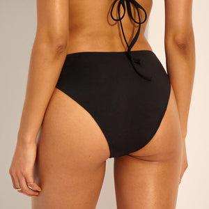 Model trägt ooia Perioden Bademode Slip in schwarz.
hinten