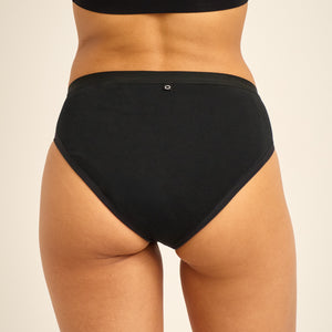 Modell trägt ooia Slip Basic Extra Strong in Schwarz – Periodenunterwäsche im klassischen Design aus Baumwolle mit hoher Saugstärke.
hinten