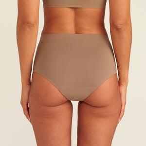 Modell trägt ooia Periodenunterwäsche Highwaist Seamless in Taupe mit hohem Bund und nahtlosem Design, Rückansicht