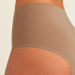 Modell trägt ooia Periodenunterwäsche Highwaist Seamless in Taupe mit hohem Bund und nahtlosem Design, Detailansicht