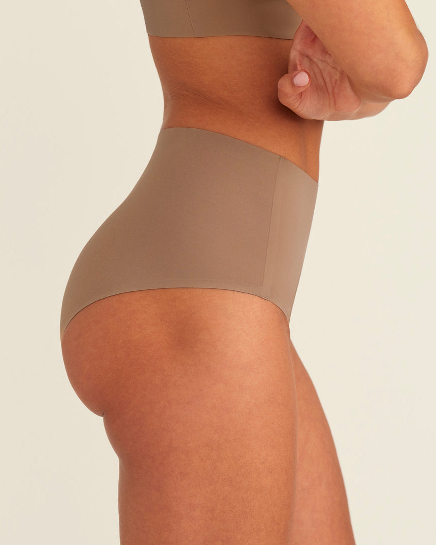 Modell trägt ooia Periodenunterwäsche Highwaist Seamless in Taupe mit hohem Bund und nahtlosem Design