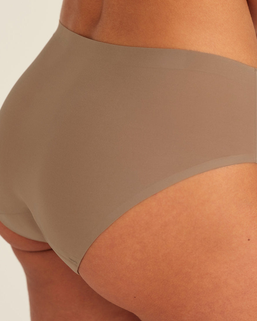 Modell trägt ooia Periodenunterwäsche Hipster Seamless in Taupe mit nahtlosem Design, Detailansicht