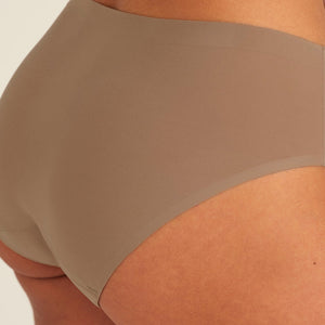 Modell trägt ooia Periodenunterwäsche Hipster Seamless in Taupe mit nahtlosem Design, Detailansicht