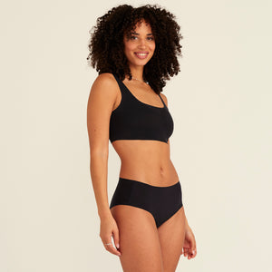 Modell trägt ooia Hipster Seamless Extra Strong in Schwarz – nahtlose Unterwäsche für eine starke Periode