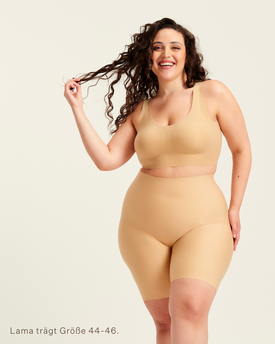 kurviges Modell trägt ooia Shape Short Thigh Saving in Beige – figurformende Short mit Oberschenkelschutz.