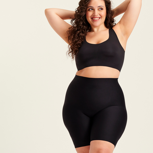 kurviges Modell trägt ooia Shape Short Thigh Saving in Schwarz – figurformende Short mit Oberschenkelschutz.