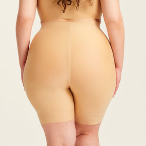 kurviges Modell trägt ooia Shape Short Thigh Saving in Beige – figurformende Short mit Oberschenkelschutz. Rückansicht.