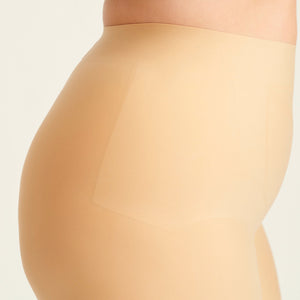 kurviges Modell trägt ooia Shape Short Thigh Saving in Beige – figurformende Short mit Oberschenkelschutz. Detailansicht.