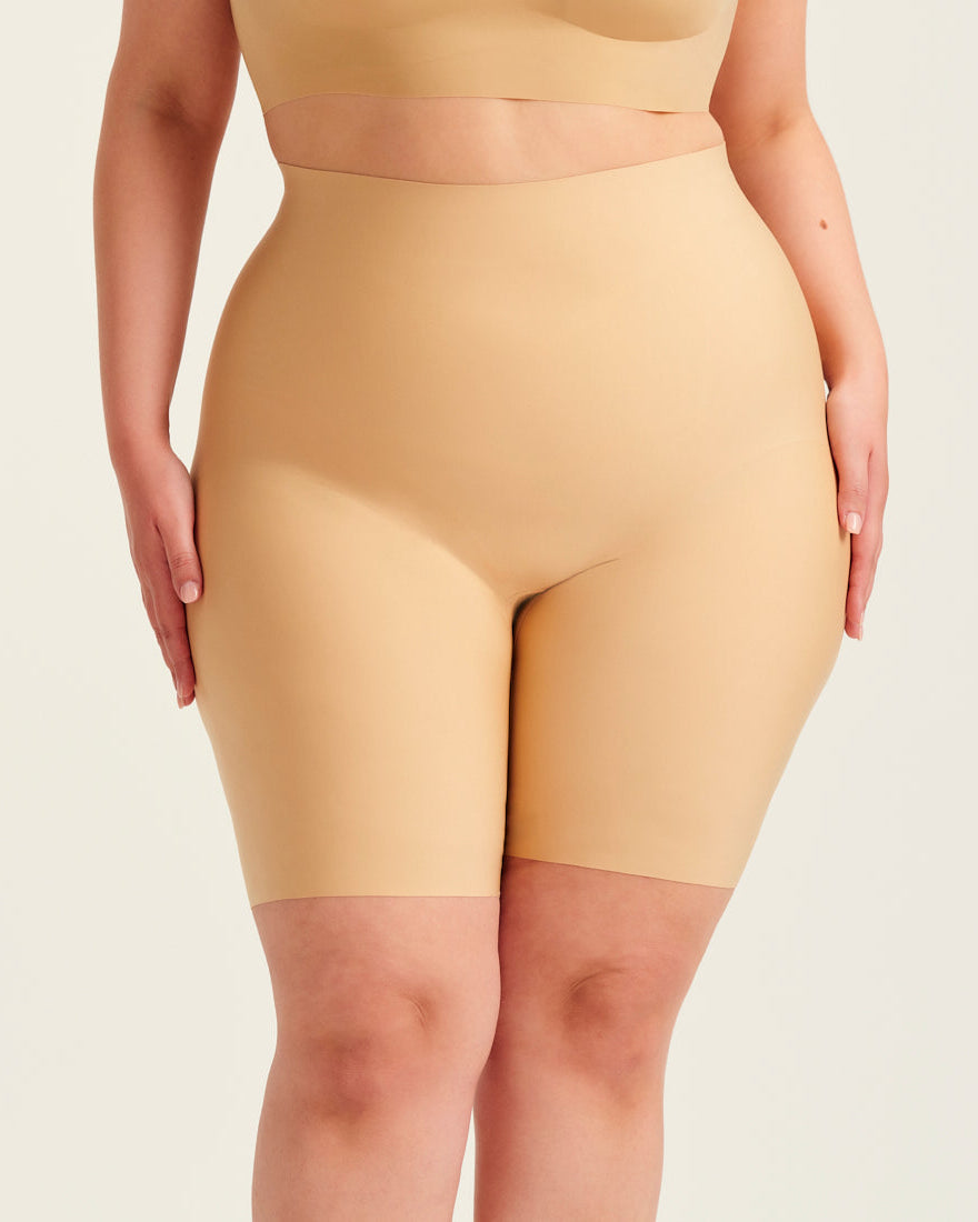 kurviges Modell trägt ooia Shape Short Thigh Saving in Beige – figurformende Short mit Oberschenkelschutz