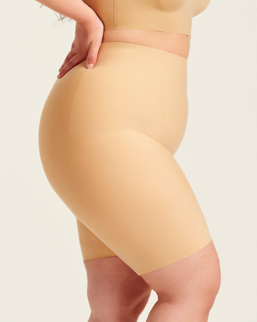 kurviges Modell trägt ooia Shape Short Thigh Saving in Beige – figurformende Short mit Oberschenkelschutz