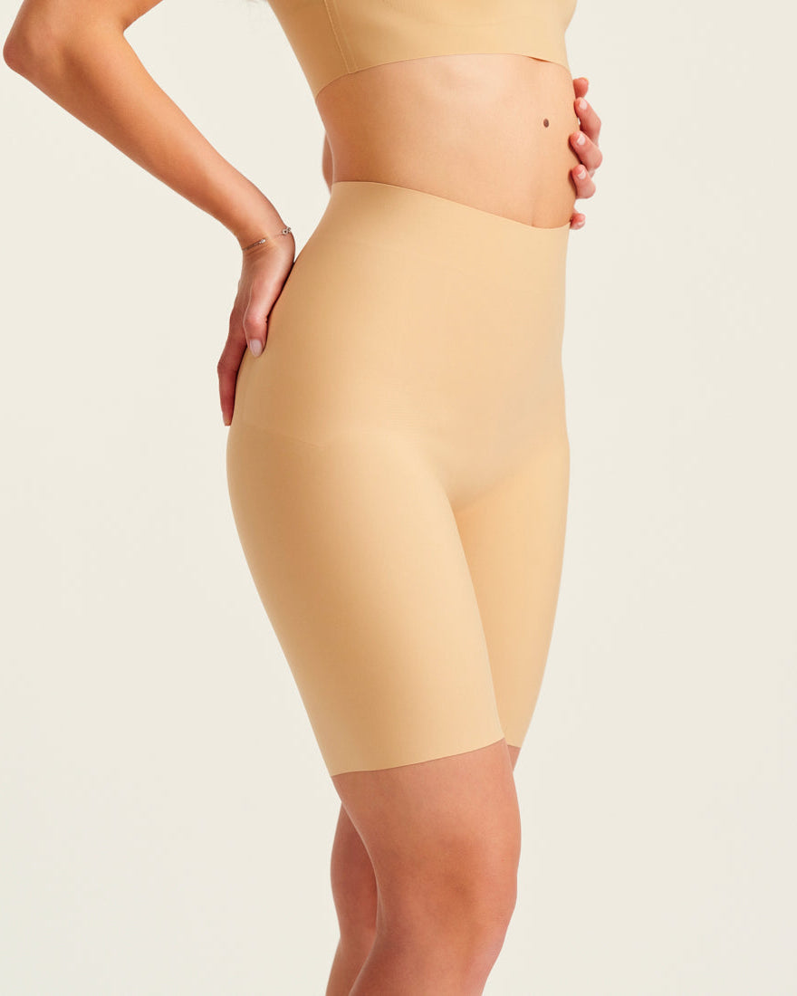 Modell trägt ooia Shape Short Thigh Saving in Beige – figurformende Short mit Oberschenkelschutz