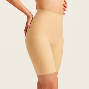 Modell trägt ooia Shape Short Thigh Saving in Beige – figurformende Short mit Oberschenkelschutz