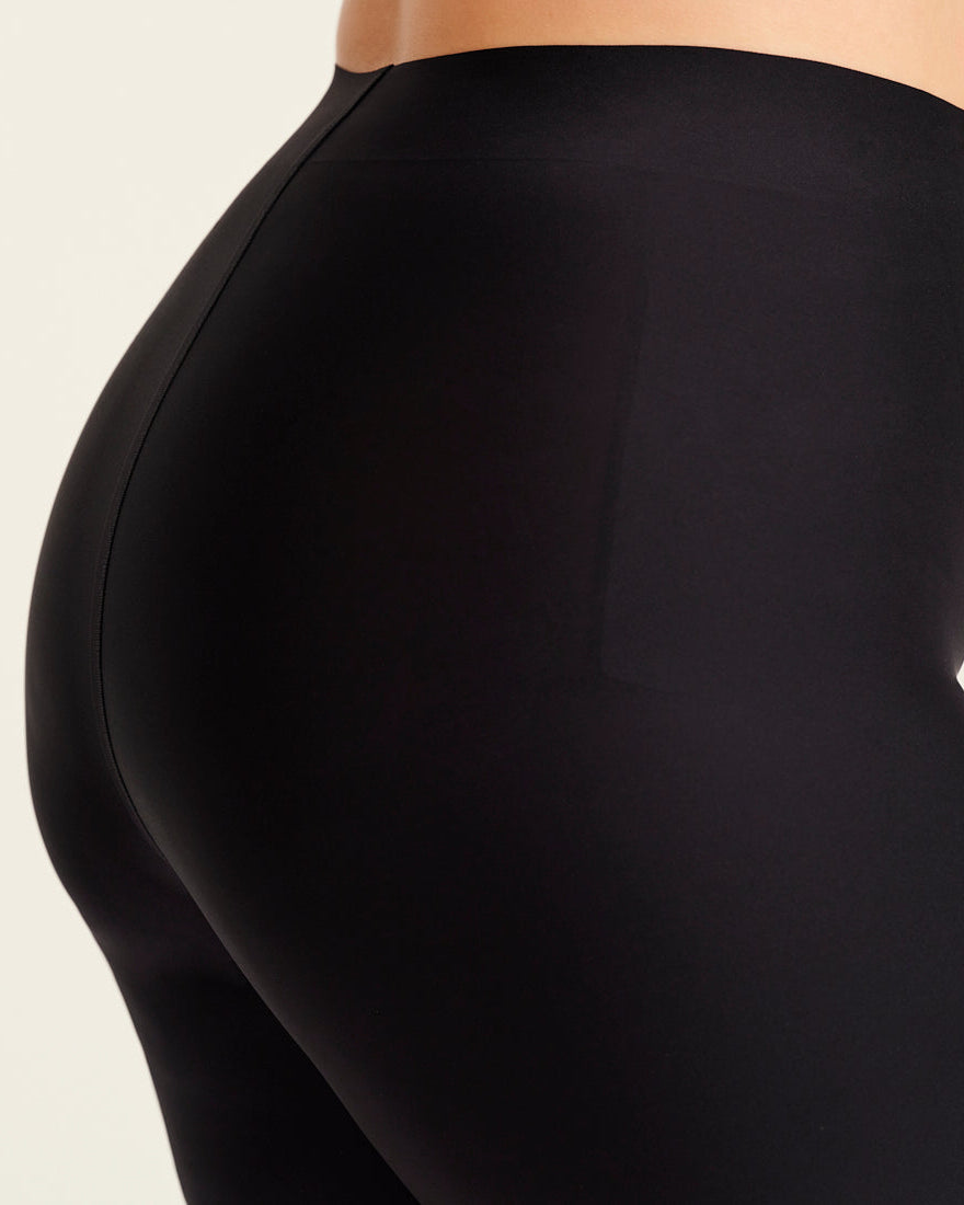 kurviges Modell trägt ooia Shape Short Thigh Saving in Schwarz – figurformende Short mit Oberschenkelschutz. Detailansicht.