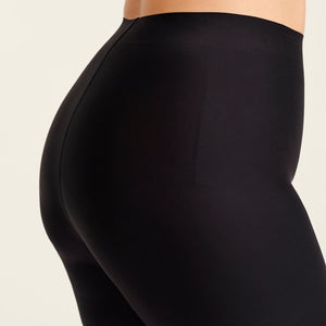 kurviges Modell trägt ooia Shape Short Thigh Saving in Schwarz – figurformende Short mit Oberschenkelschutz. Detailansicht.