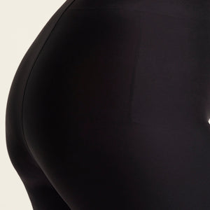 kurviges Modell trägt ooia Shape Short Thigh Saving in Schwarz – figurformende Short mit Oberschenkelschutz. Detailansicht.