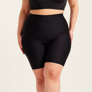 kurviges Modell trägt ooia Shape Short Thigh Saving in Schwarz – figurformende Short mit Oberschenkelschutz