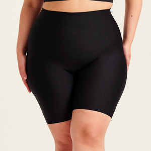 kurviges Modell trägt ooia Shape Short Thigh Saving in Schwarz – figurformende Short mit Oberschenkelschutz