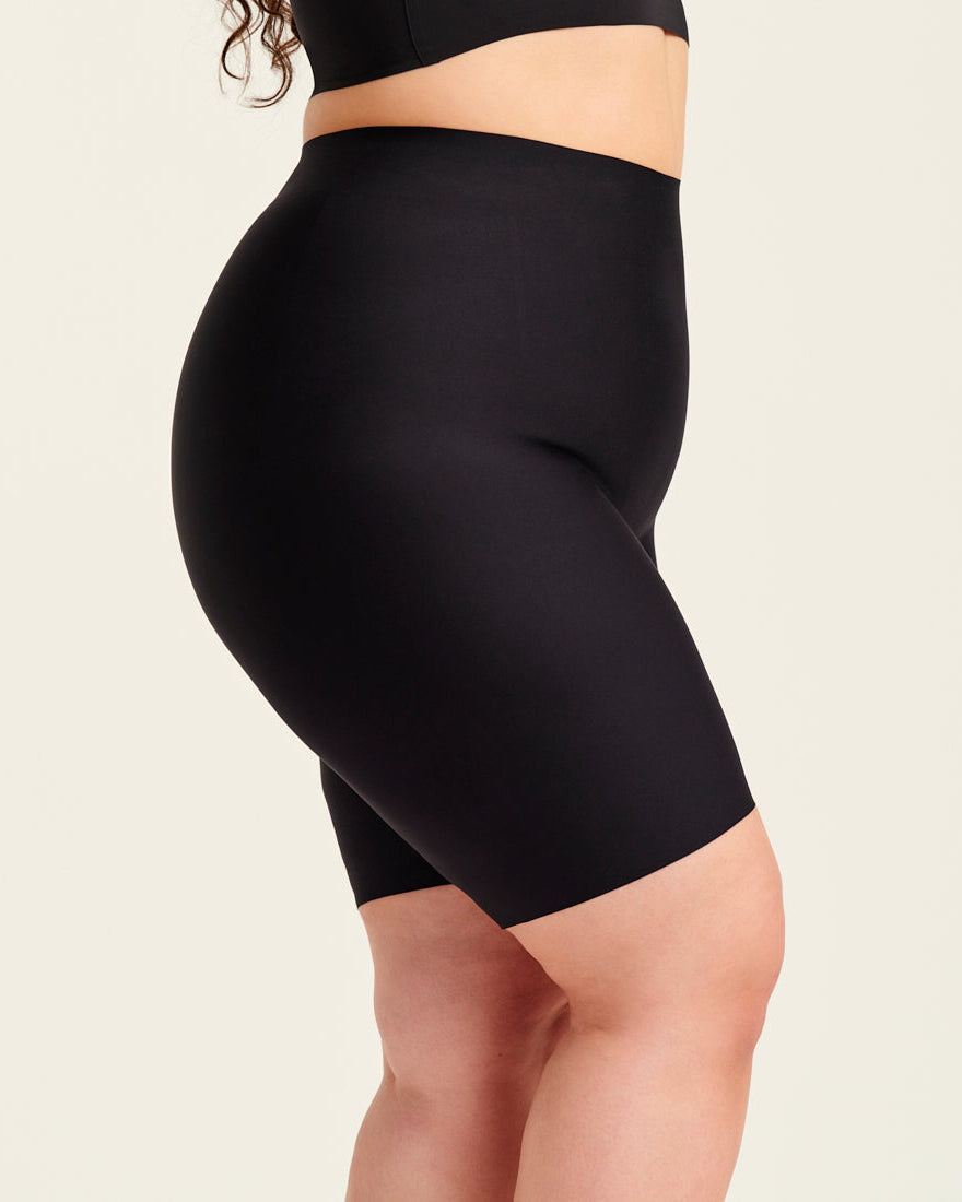 kurviges Modell trägt ooia Shape Short Thigh Saving in Schwarz – figurformende Short mit Oberschenkelschutz