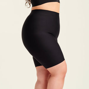 kurviges Modell trägt ooia Shape Short Thigh Saving in Schwarz – figurformende Short mit Oberschenkelschutz