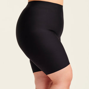 kurviges Modell trägt ooia Shape Short Thigh Saving in Schwarz – figurformende Short mit Oberschenkelschutz