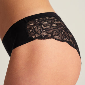 Modell trägt ooia Everyday Hipster Seamless Lace in Schwarz, nahlos vorn und Spitze am Gesäß – ersetzt Slipeinlagen, Detailansicht