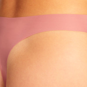 Modell trägt ooia Seamless String in Dusky Pink – nahtlose Periodenunterwäsche mit leichter Saugstärke. Detailansicht.