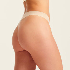 Modell trägt ooia Periodenunterwäsche String Seamless in Beige - nahtloser String mit leichter Saugstärke
