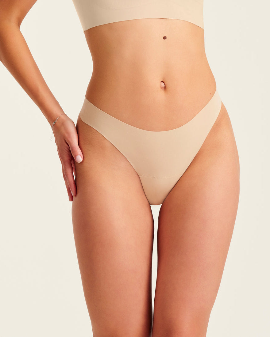 Modell trägt ooia Periodenunterwäsche String Seamless in Beige - nahtloser String mit leichter Saugstärke