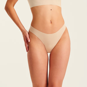 Modell trägt ooia Periodenunterwäsche String Seamless in Beige - nahtloser String mit leichter Saugstärke