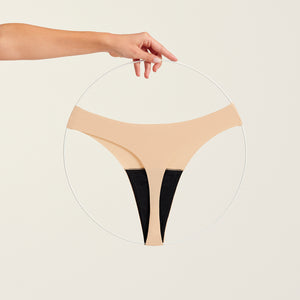 Modell trägt ooia Periodenunterwäsche String Seamless in Beige - nahtloser String mit leichter Saugstärke. Freisteller.