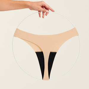 Modell trägt ooia Periodenunterwäsche String Seamless in Beige - nahtloser String mit leichter Saugstärke. Freisteller.