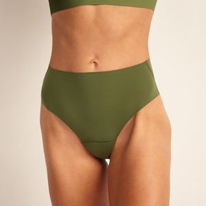 Modell trägt ooia Highwaist Seamless Cheeky in Khaki – nahtlose Periodenunterwäsche mit hoch geschnittenen Beinausschnitt.