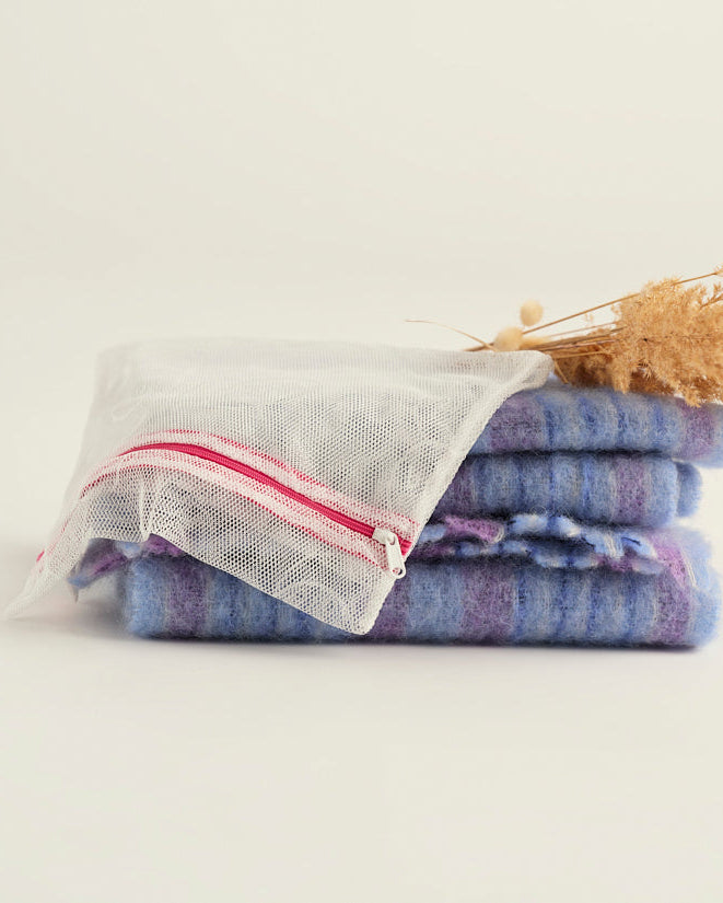Ooia Washbag aus feinmaschigem Netzmaterial – ideal zum Waschen von Periodenunterwäsche in der Maschine. ooia Washbag liegt auf Handtüchern.